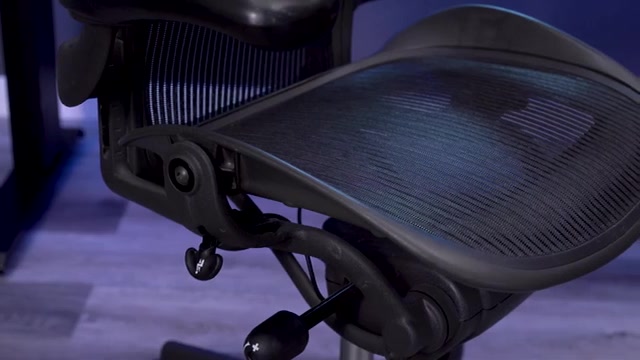 Het geweven zitvlak van de Aeron met daaronder het kantelmechanisme en de instelhendels