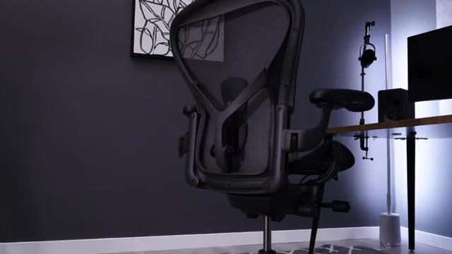 Zwarte Herman Miller Aeron bureaustoel met geweven rug aan een bureau