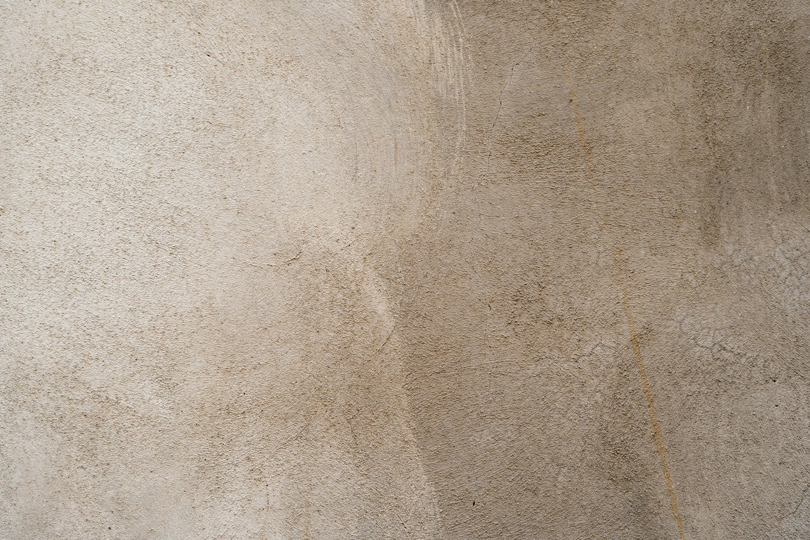 Beige woonkamer met ronde meubels en een gepleisterde muur